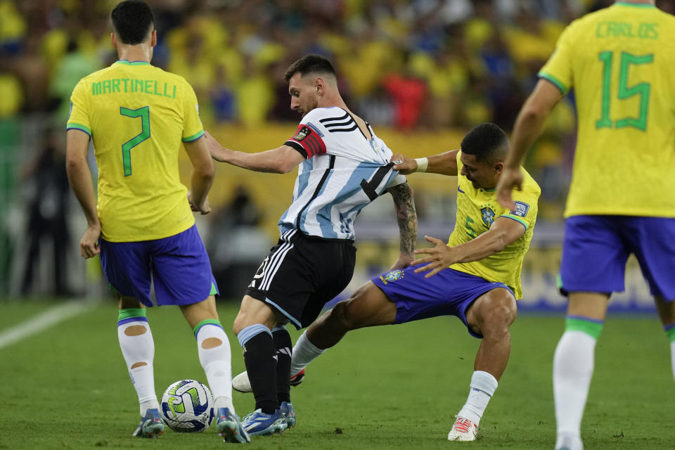 El brasileño Andre sujeta de la camiseta al delantero argentino Lionel Messi en el partido contra Brasil en las eliminatorias del Mundial 2026, el martes 21 de noviembre de 2023, en Río de Janeiro. (AP Foto/Silvia Izquierdo)