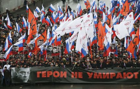 People march behind a banner to commemorate Kremlin critic Boris Nemtsov, who was shot dead on Friday night, in central Moscow March 1, 2015. The banner reads, "Heroes don't die". REUTERS/Maxim Zmeyev