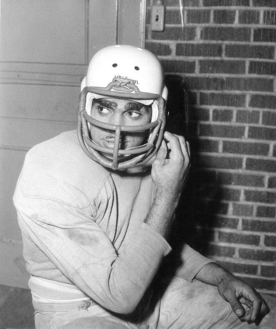 Drake star Johnny Bright tries on a helmet with a protective facemask less than a week after his jaw was broken by an Oklahoma A&M player in October 1951.
