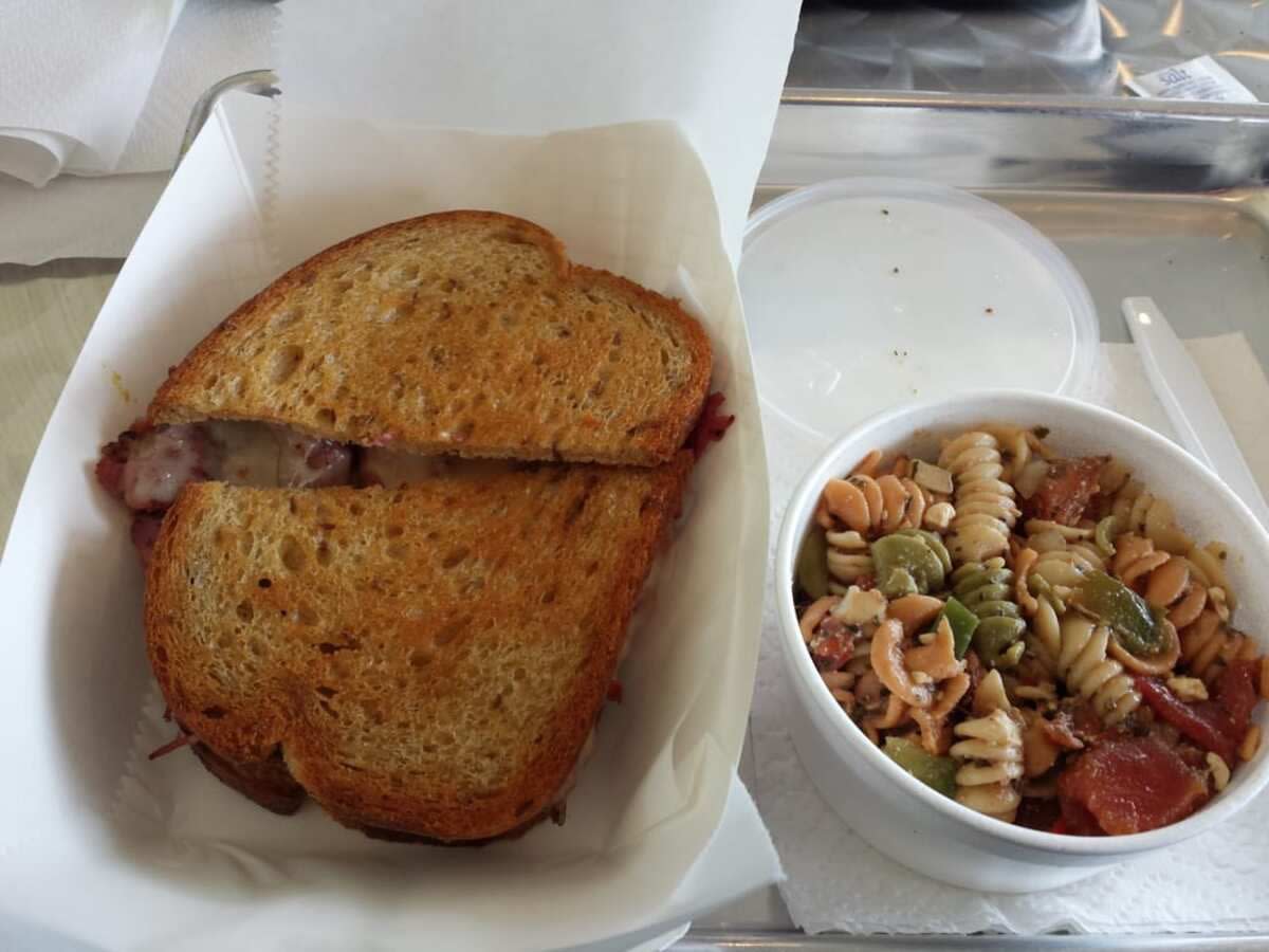 The Gobbler Sandwich on the left next to a side of noodle salad, TJ's Sandwich Shop, Fayetteville, Arkansas, on a tray on a table