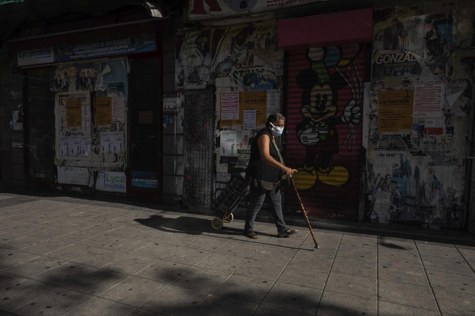 A woman wearing a face mask to prevent the spread of the coronavirus walks in the southern neighbourhood of Vallecas in Madrid, Spain, Monday, Sept. 21, 2020. Police in the Spanish capital and its surrounding towns are stopping people coming in and out of working-class neighborhoods that have been partially locked down to stem Europe's fastest coronavirus spread. (AP Photo/Bernat Armangue)