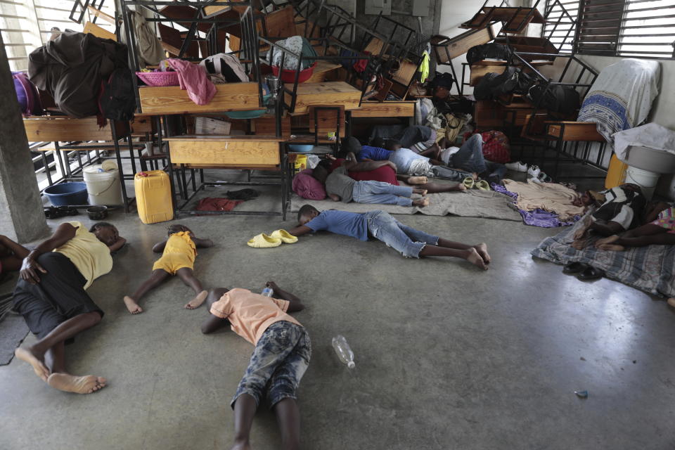 People displaced by the latest episode of gang violence take refuge at a school turned into a shelter, in the Carrefour-Feuilles neighborhood of Port-au-Prince,, Haiti, Wednesday, Aug. 16, 2023. Prime Minister Ariel Henry, who has led Haiti since the July 2021 assassination of President Jovenel Moïse, has been pushing for the deployment of a foreign armed force since October to help fight powerful gangs that control large areas of the capital Port-au-Prince. (AP Photo/Odelyn Joseph)