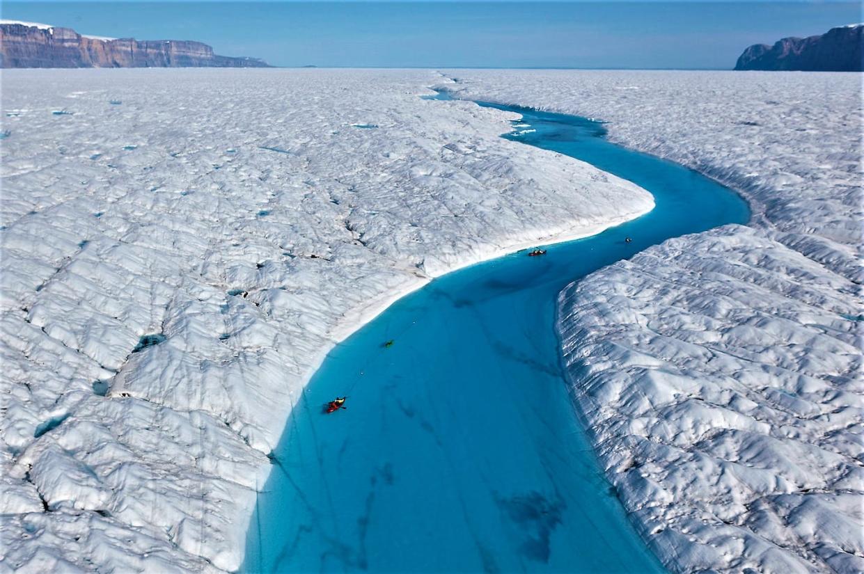 Richard Bates and Alun Hubbard kayak a meltwater stream on Greenland's Petermann Glacier, towing an ice radar that reveals it's riddled with fractures. Nick Cobbing.