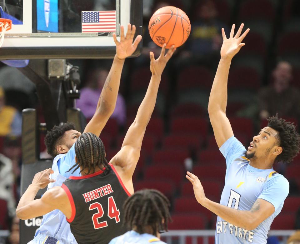 Northern Illinois' Darweshi Hunter is defended at the basket by Kent's Miryne Thomas, left, and Julius Rollins in a MAC quarterfinal on Thursday, March 9, 2023 in Cleveland.