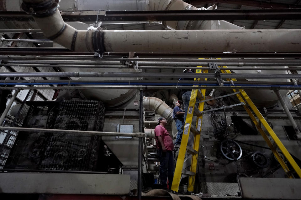 Workers make repairs as gins sit idle at Quarterly Cotton Growers, Tuesday, Oct. 4, 2022, near Plainview, Texas. Drought and extreme heat have severely damaged much of the cotton harvest in the U.S., which produces roughly 35% of the world's crop. (AP Photo/Eric Gay)