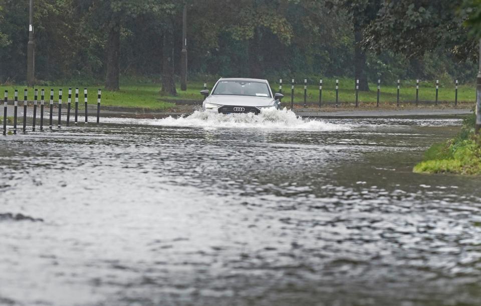 A car driving through floodwater in Cork (PA)
