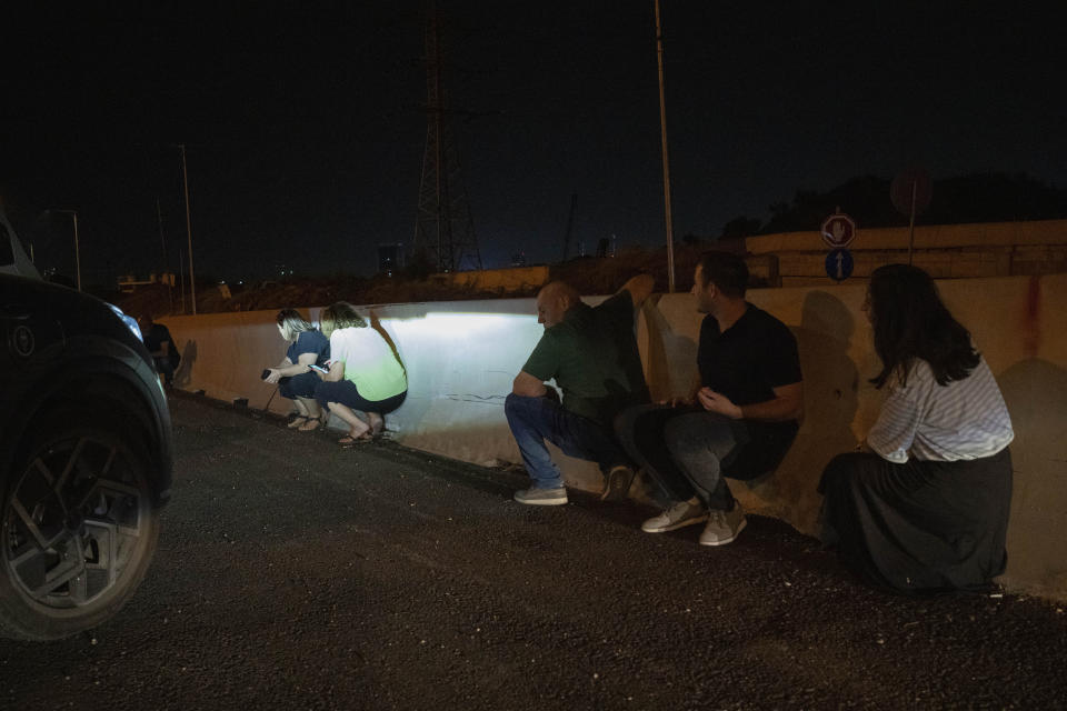 Drivers take cover during an airstrike alarm outskirts of Tel Aviv, Israel, Tuesday, Oct. 31, 2023. (AP Photo/Bernat Armangue)