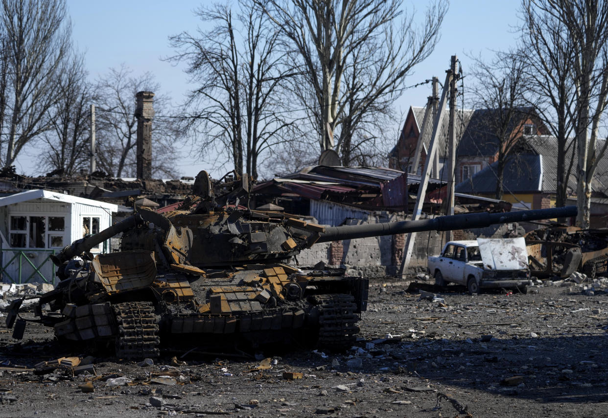 Destroyed buildings and a military vehicle.