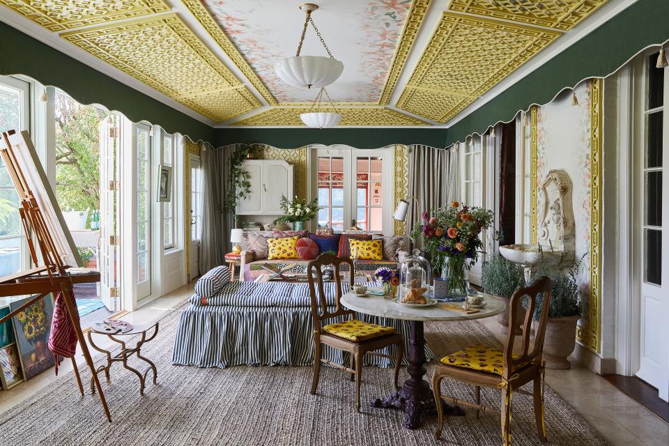 Centered by Design transformed the sunroom of a David Adler–designed property in Illinois for the House Beautiful Whole Home 2023. Claire Staszak incorporated yellow trellises, cheerful prints, and blue-and-white stripes in the spirited space.