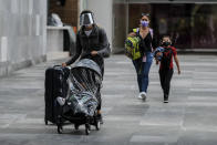 Passengers walk through the airport wearing face masks amid the COVID-19 pandemic in Cancun, Mexico, Saturday, June 13, 2020. In Quintana Roo state, where Cancun is located, tourism is the only industry there is, and Cancun is the only major Mexican resort to reopen so far. (AP Photo/Victor Ruiz)