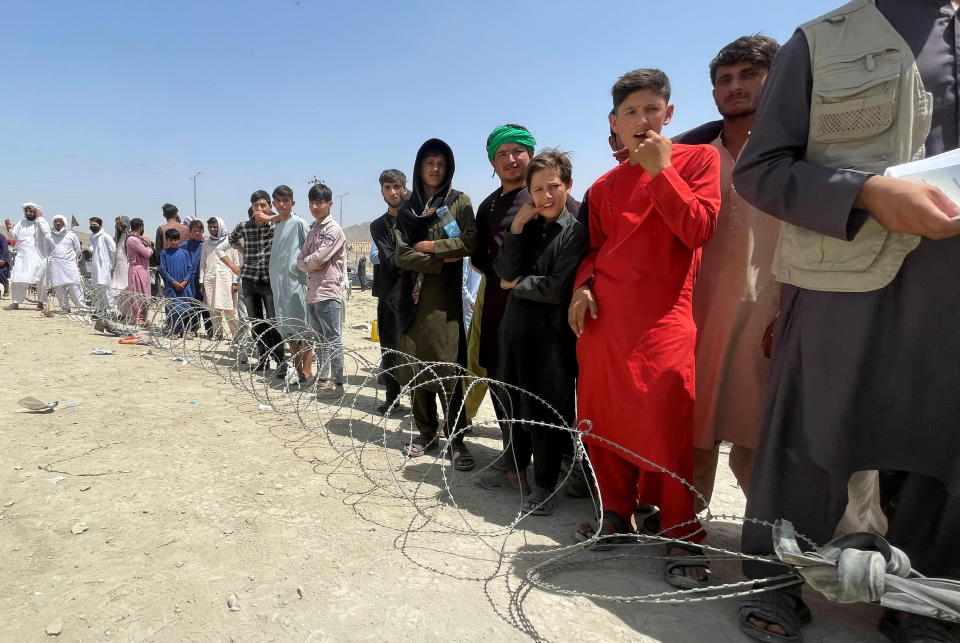 People wait outside Hamid Karzai International Airport in Kabul on Tuesday. 