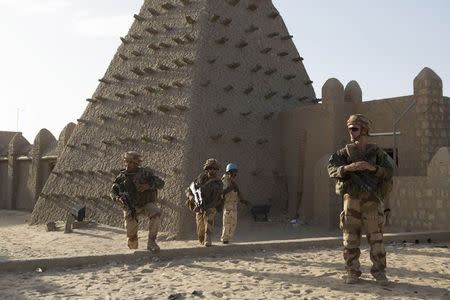 French soldiers and UN peacekeepers from Burkina Faso patrol in front of the Sankore Mosque in Timbuktu November 5, 2014. REUTERS/Joe Penney