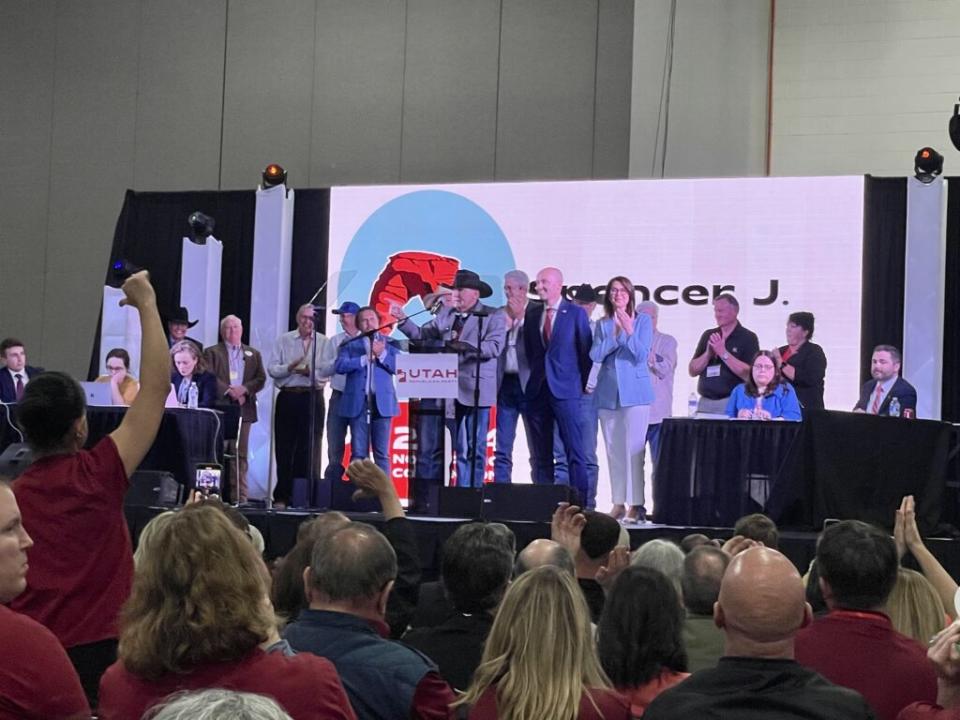  Utah Gov. Spencer Cox, to the right of the podium, appears on stage with supporters as some delegates in the audience give a thumbs down at the Utah Republican Party’s nominating convention in Salt Lake City on Saturday, April 27, 2024. (Katie McKellar / Utah News Dispatch)