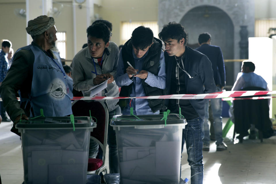 Observadores electorales y funcionarios de la Comisión Electoral Independiente, conversan durante el segundo día de elecciones parlamentarias en Kabul, Afganistán, el domingo 21 de octubre de 2019. (AP Foto/Massoud Hossaini)