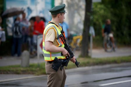 A police officer secures a road near to the scene of a shooting rampage at the Olympia shopping mall in Munich, Germany July 22, 2016. REUTERS/Michael Dalder