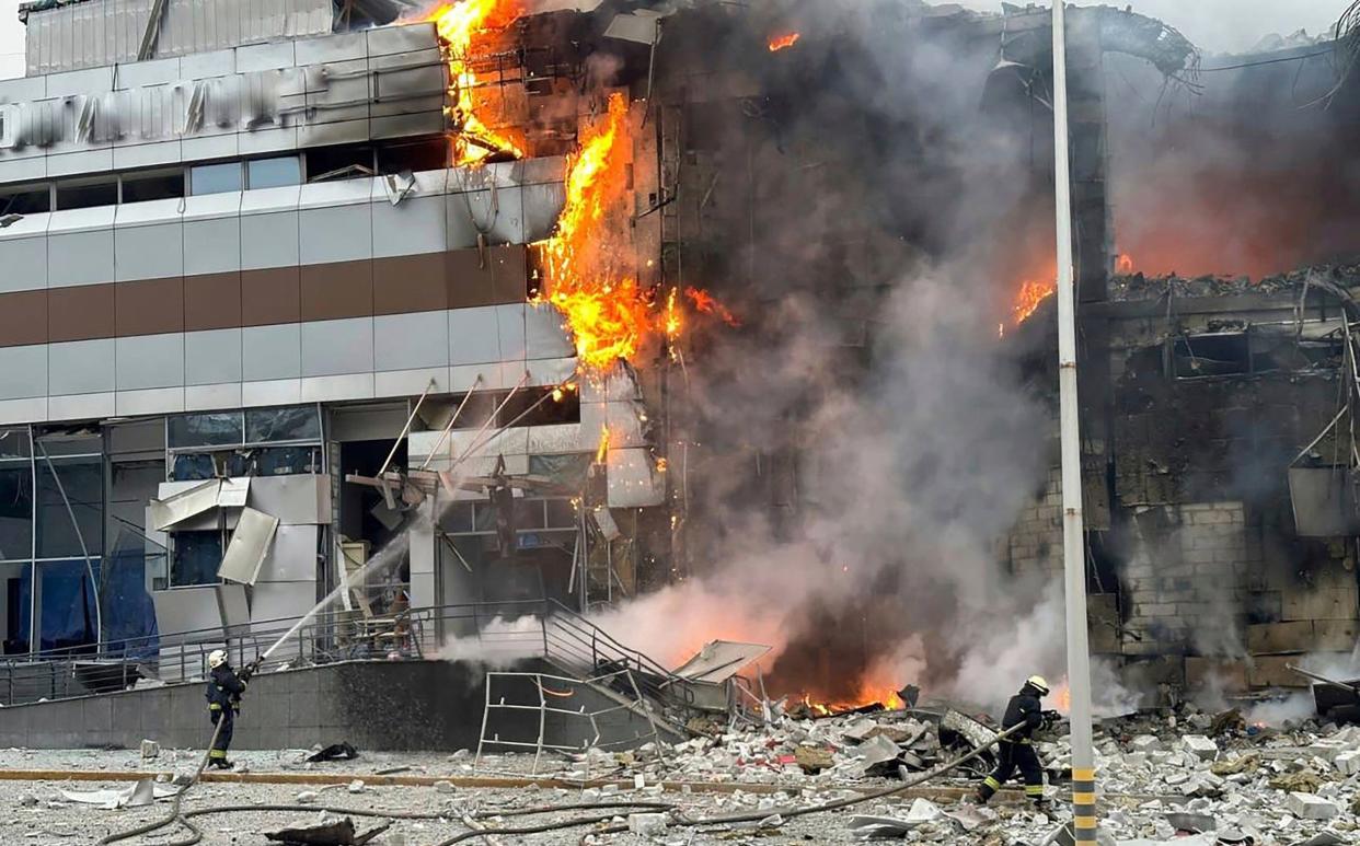 Firefighters work at a building damaged in a Russian attack on Kyiv on Friday