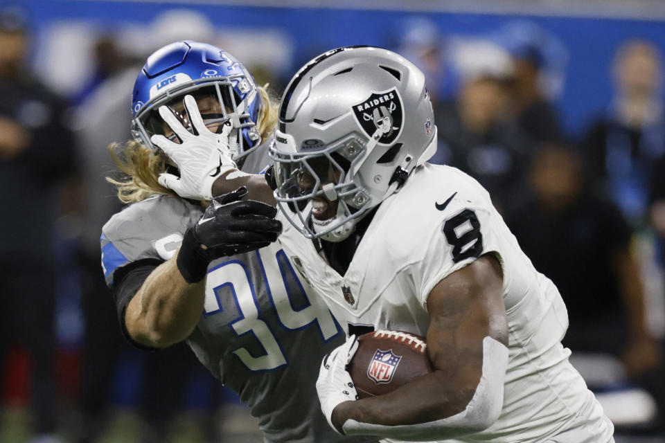Las Vegas Raiders running back Josh Jacobs (8) stiff arms Detroit Lions linebacker Alex Anzalone (34) during the first half of an NFL football game, Monday, Oct. 30, 2023, in Detroit. (AP Photo/Duane Burleson)