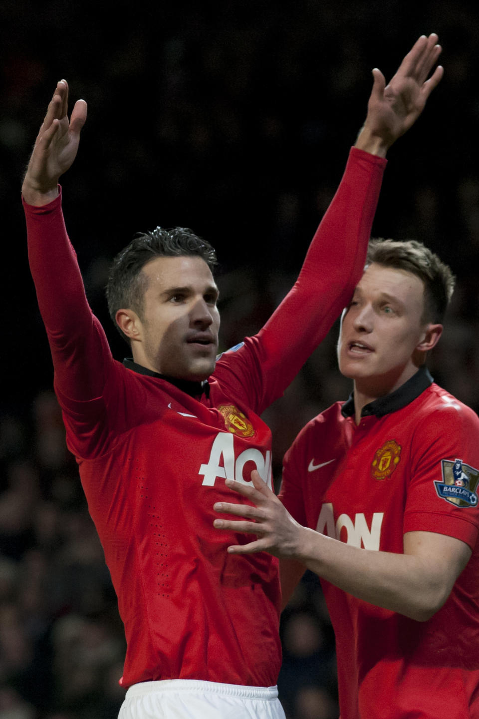 Manchester United's Robin van Persie, left, celebrates with teammate Phil Jones after scoring against Cardiff City during their English Premier League soccer match at Old Trafford Stadium, Manchester, England, Tuesday Jan. 28, 2014. (AP Photo/Jon Super)