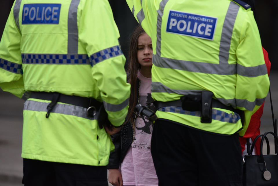 <p>A woman and a young girl wearing a t-shirt of U.S. singer Ariana Grande talks to police near Manchester Arena following a deadly terror attack in Manchester, northwest England on May 23, 2017. (Oli Scarff/AFP/Getty Images) </p>