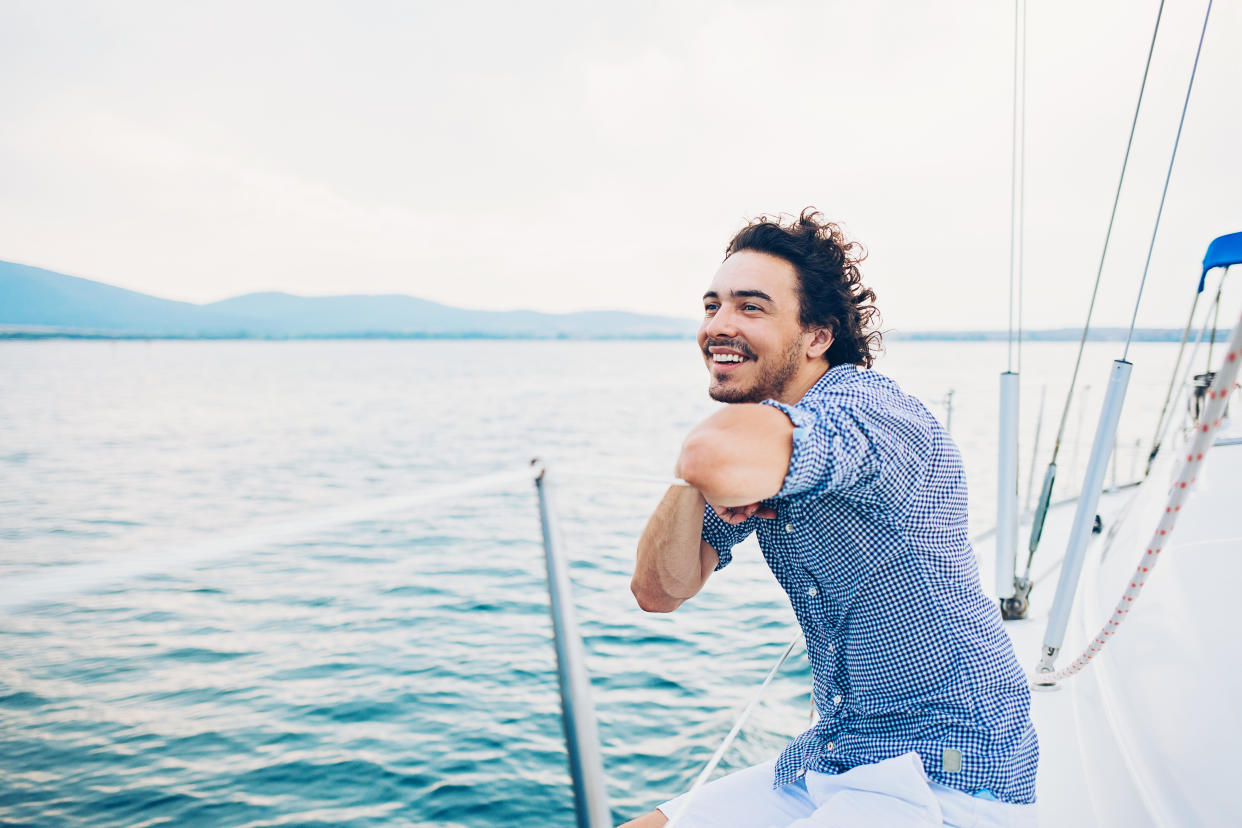 Young man on a yacht looking at the sea, with copy space.