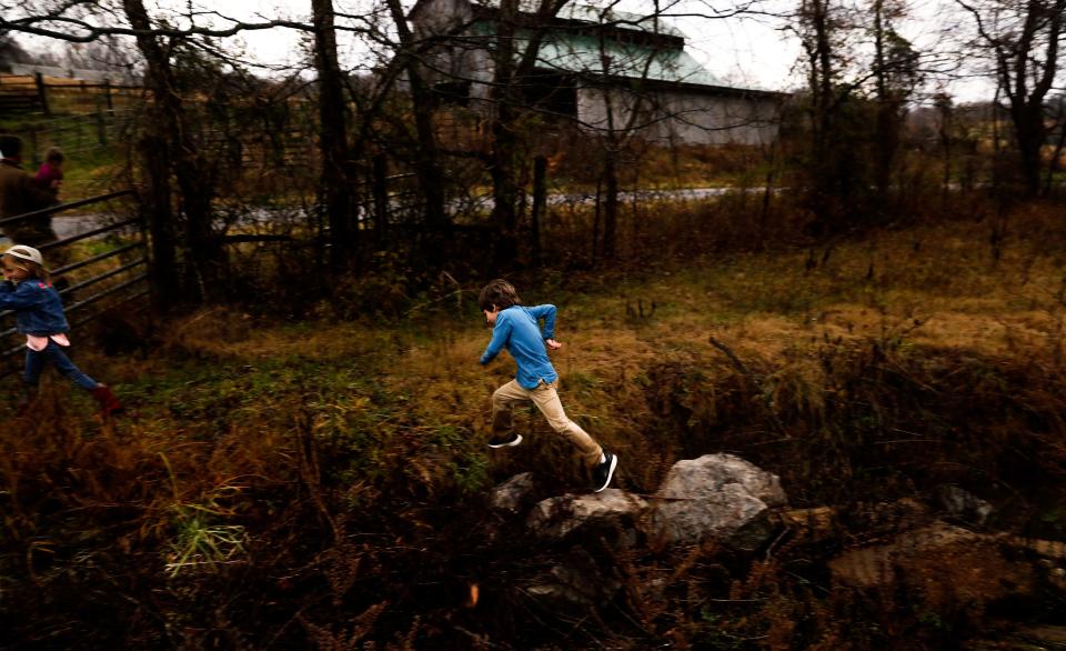 Sam Kennedy IV jumps over a stream on the Kettle Mills Farm in Columbia, Tenn. on Nov. 29, 2022. 