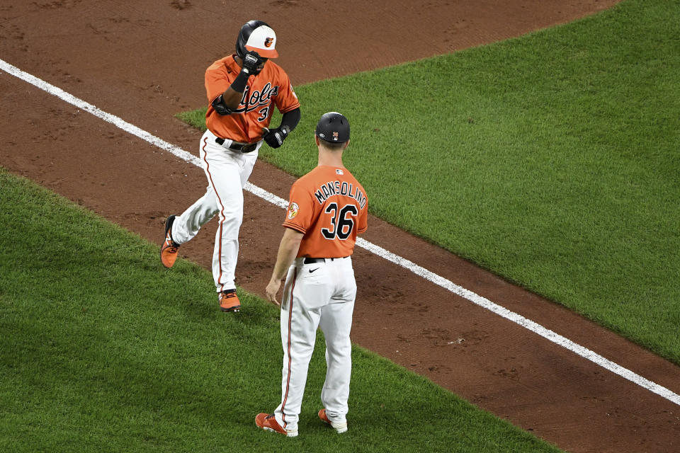 Baltimore Orioles' Cedric Mullins celebrates with third base coach Tony Mansolino (36) after hitting a two-run home run against the Tampa Bay Rays during the third inning of a baseball game Saturday, Aug. 7, 2021, in Baltimore. (AP Photo/Will Newton)