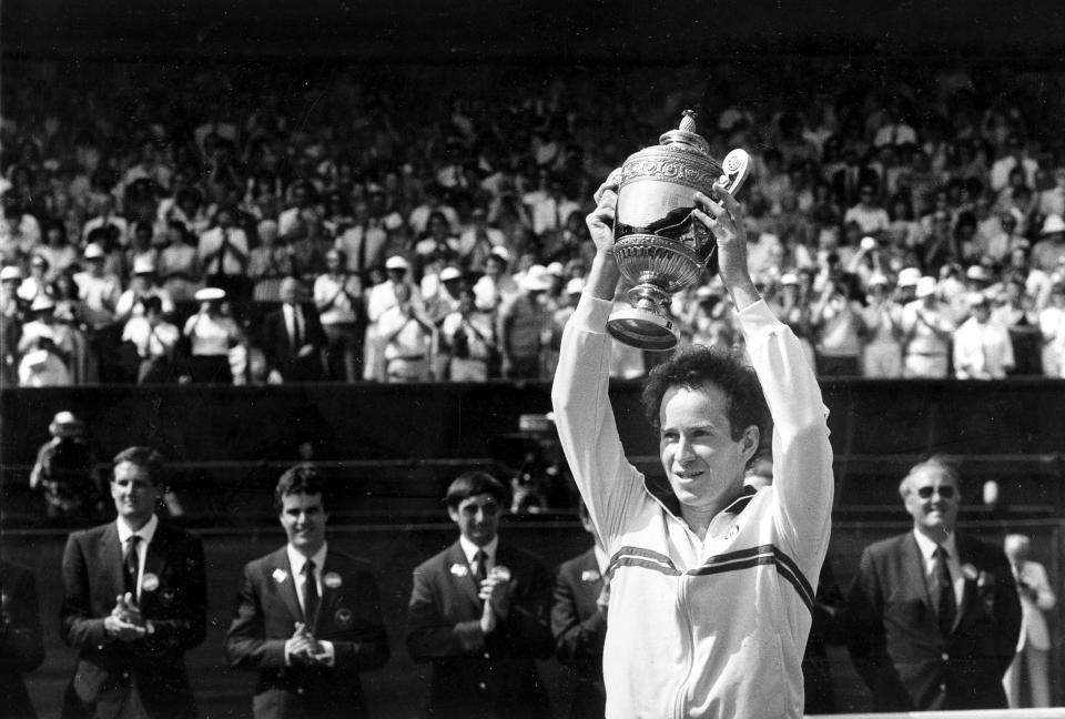 FILE - In this July 8, 1984, file photo, John McEnroe, of the United States, lifts the trophy after defeating fellow American Jimmy Connors, 6-1, 6-1, 6-2, in the men's singles final on Wimbledon's center court. (AP Photo/Dave Caulkin, File)