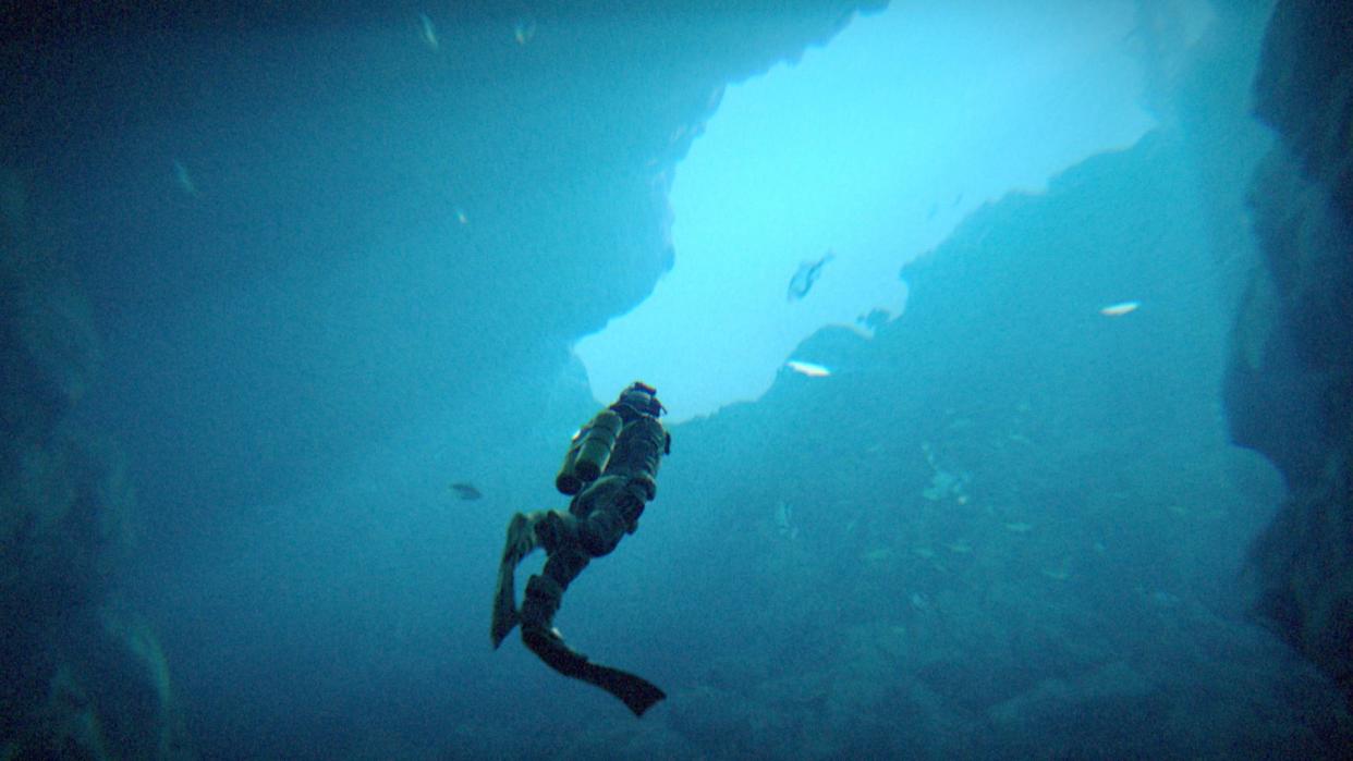  Third person shot of deep-sea diving in a cave in Under the Waves 