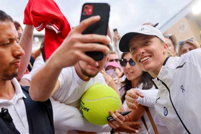 Poland's Iga Swiatek poses with fans after winning the women's final of the French Open with a 6-2 5-7 6-4 win against Karolina Muchova of the Czech Republic 