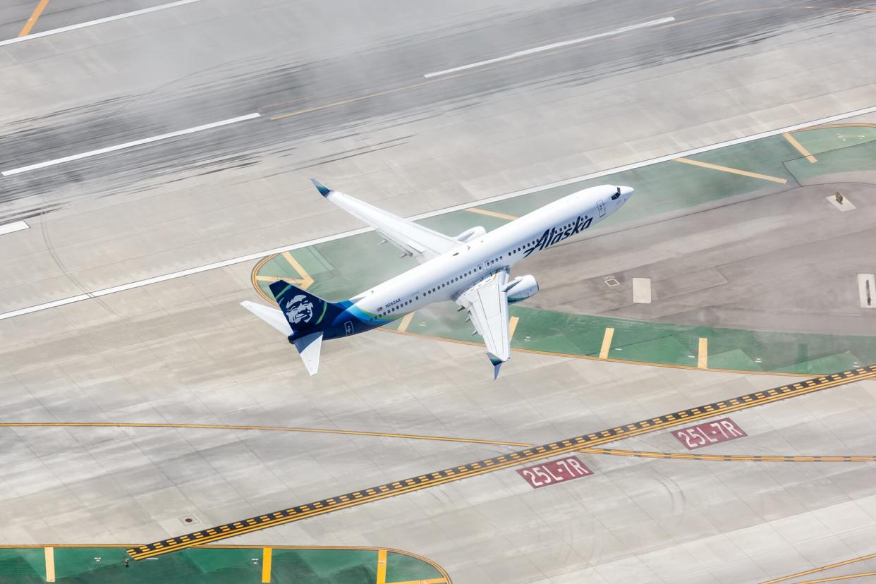 Alaska Airlines Boeing 737-900ER airplane at Los Angeles International Airport (LAX) in California aerial view.