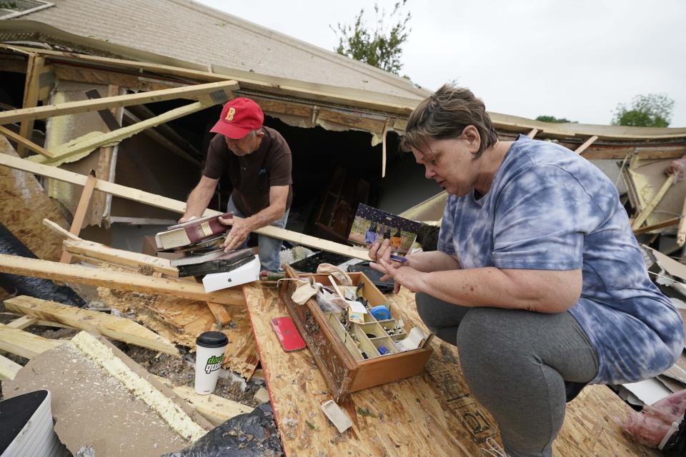 Vickie Savell, right, looks for her wedding band, as a friend and fellow church member pulls possessions from the remains of her new mobile home early Monday, May 3, 2021, in Yazoo County, Miss. Multiple tornadoes were reported across Mississippi on Sunday, causing some damage but no immediate word of injuries. (AP Photo/Rogelio V. Solis)