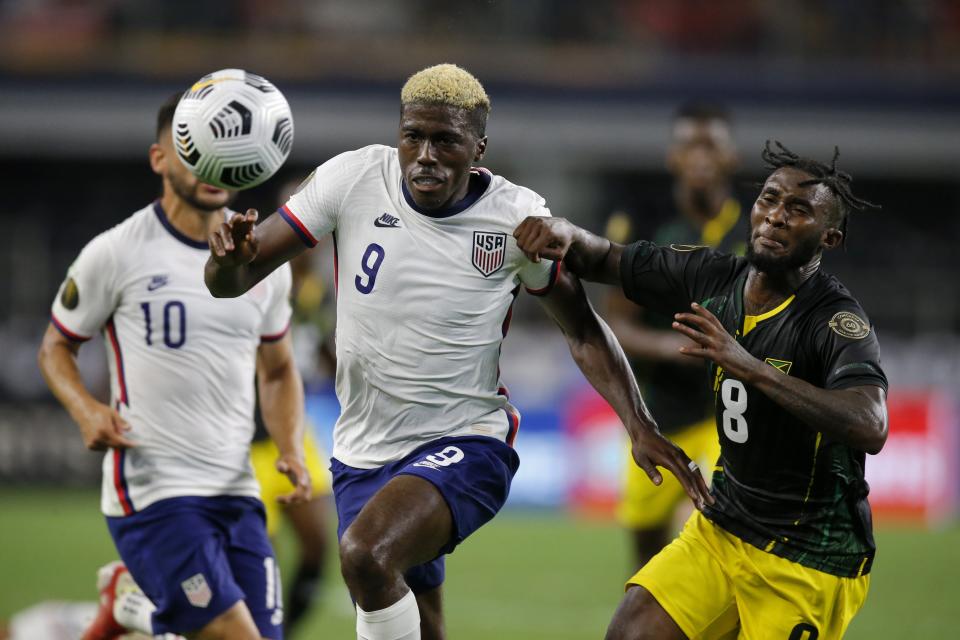 United States forward Gyasi Zardes (9) and Jamaica's Oniel Fisher (8) chase after a loose ball in the second half of a CONCACAF Gold Cup quarterfinals soccer match, Sunday, July 25, 2021, in Arlington, Texas. (AP Photo/Brandon Wade)