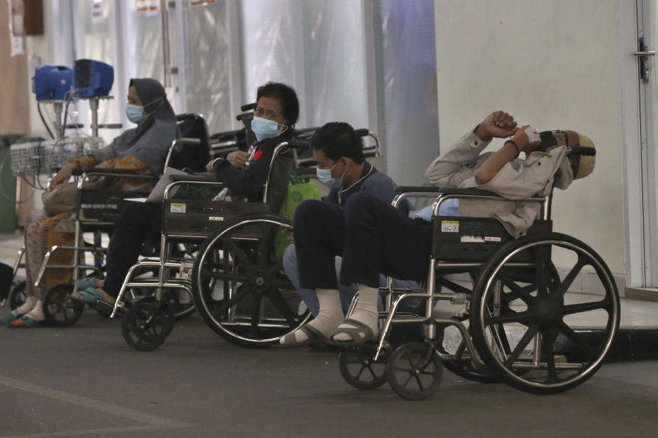 People wait for medical treatment outside an emergency ward amid a surge of COVID-19 patients at Cengkareng Regional General Hospital in Jakarta, Indonesia, Thursday, June 24, 2021. The world's fourth most populous country, has seen COVID-19 infections surge in recent weeks, putting pressure on hospitals, including in the capital city, where most of hospital beds are full, and has added urgency to the government's plan to inoculate 1 million people each day by next month. (AP Photo/Tatan Syuflana)