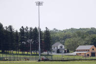 The Field of Dreams movie site, rear, is seen as construction of a baseball field continues, Friday, June 5, 2020, in Dyersville, Iowa. Major League Baseball is building the field a few hundred yards down a corn-lined path from the famous movie site in eastern Iowa but unlike the original, it's unclear whether teams will show up for a game this time as the league and its players struggle to agree on plans for a coronavirus-shortened season. (AP Photo/Charlie Neibergall)