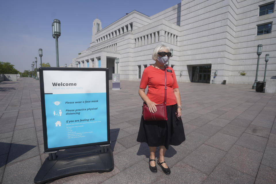 FILE - In this Aug. 26, 2021, file photo, The Church of Jesus Christ of Latter-day Saints church member Rebecca Richards wears a mask outside the The Church of Jesus Christ of Latter-day Saints Conference Center in Salt Lake City. The Church of Jesus Christ of Latter-day Saints has announced that face masks will be required inside temples to limit the spread of COVID-19. Church leaders said Wednesday, Sept. 22, 2021, that masks will be required temporarily in an effort to keep temples open. (AP Photo/Rick Bowmer, File)