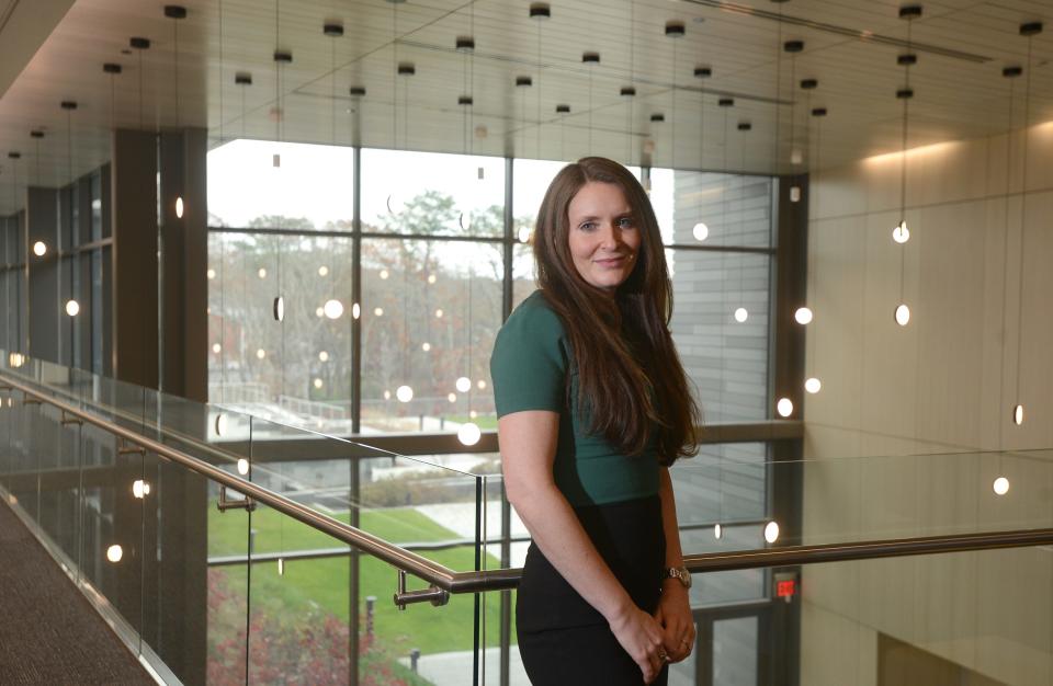 Maggie Phelan poses at the Cape Cod 5 bank headquarters on Wednesday. She chose to work at the bank because of its climate change related policies and benefits.