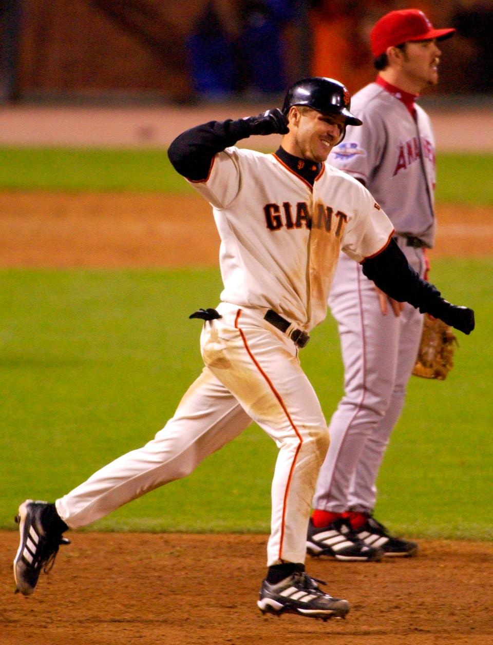 Jeff Kent von den Giants jubelt, indem er in Spiel 5 der World Series im Jahr 2002 einen Homerun mit zwei Läufen hinter Scott Spizzio, dem ersten Basisspieler der Anaheim Angels, schlägt.