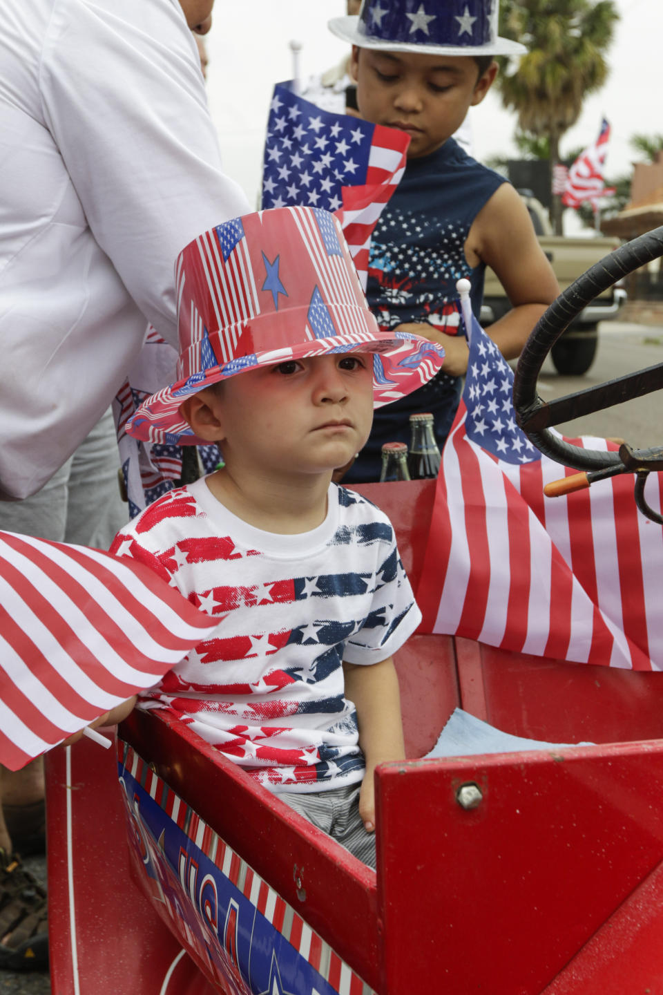 Caleb Reyna waits in a minature motorcar for the parade to start Thursday, July 4, 2019, at the Brownsville Herald's 19th annual Salute to Freedom Fourth of July parade in Brownsville, Texas. (Denise Cathey/The Brownsville Herald via AP)