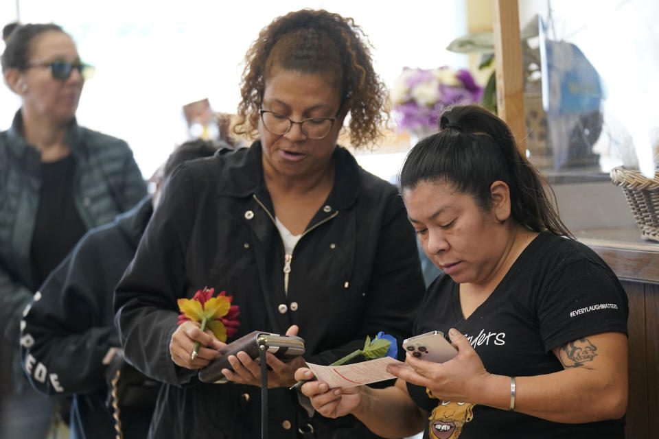 Arlene Johnson, left, and Mina Vicente, right, fill out Powerball pick their numbers while waiting to purchase lottery tickets at Lichine's Liquor & Deli in Sacramento, Calif., Monday, Oct. 31, 2022. The jackpot for Monday night's drawing soared to $1 billion after no one matched all six numbers in Saturday night's drawing. It's the fifth-largest lottery jackpot in U.S. history. (AP Photo/Rich Pedroncelli)