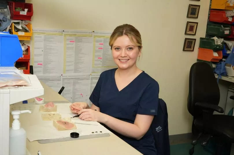 Danielle smiles as she works on creating a prosthetic ear