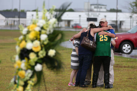 People mourn at a makeshift memorial left in memory of the victims killed in a shooting at Santa Fe High School in Santa Fe, Texas, U.S., May 23, 2018. REUTERS/Loren Elliott