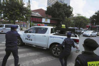 Cambodian-American lawyer Theary Seng, unseen face, is escorted by local police officers as she sits in a pickup outside the Phnom Penh Municipal Court in Phnom Penh, Cambodia, Tuesday, June 14, 2022. The Cambodian American lawyer and dozens of members of a now-dissolved opposition party were convicted of treason Tuesday in a trial that was the latest move to tame all opposition to the long-running rule of Prime Minister Hun Sen. (AP Photo/Heng Sinith)