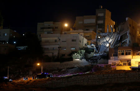 Security forces are seen near a damaged building one day after the security incident, at the city of Al Salt, Jordan, August 11, 2018. REUTERS/Muhammad Hamed