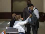 Victor Hugo Cuevas, a 26-year-old linked to a missing tiger named India, gets his tie adjusted by his grandmother, who did not wish to give her name, during a lunch break in the bond revocation hearing of a separate murder charge he's facing at Fort Bend County Justice Center on Friday, May 14, 2021, in Richmond, Texas. (Godofredo A. Vásquez/Houston Chronicle via AP)