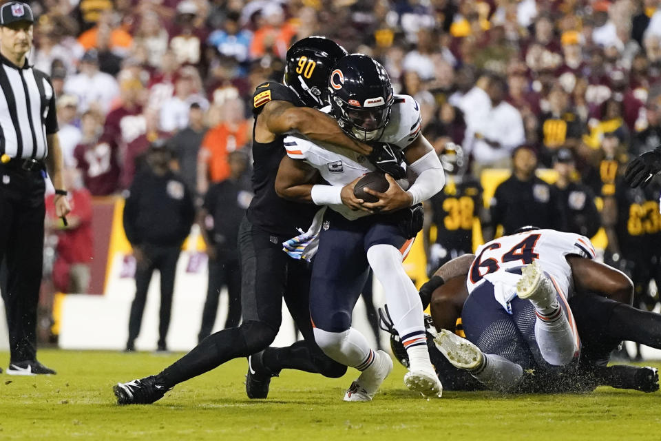 Chicago Bears quarterback Justin Fields (1) is sacked by Washington Commanders defensive end Montez Sweat (90) during the first half of an NFL football game, Thursday, Oct. 5, 2023, in Landover, Md. (AP Photo/Alex Brandon)