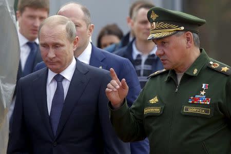 Russian President Vladimir Putin (L) listens to Defence Minister Sergei Shoigu as they arrive for the opening of the Army-2015 international military forum in Kubinka, outside Moscow, Russia, June 16, 2015. REUTERS/Maxim Shemetov