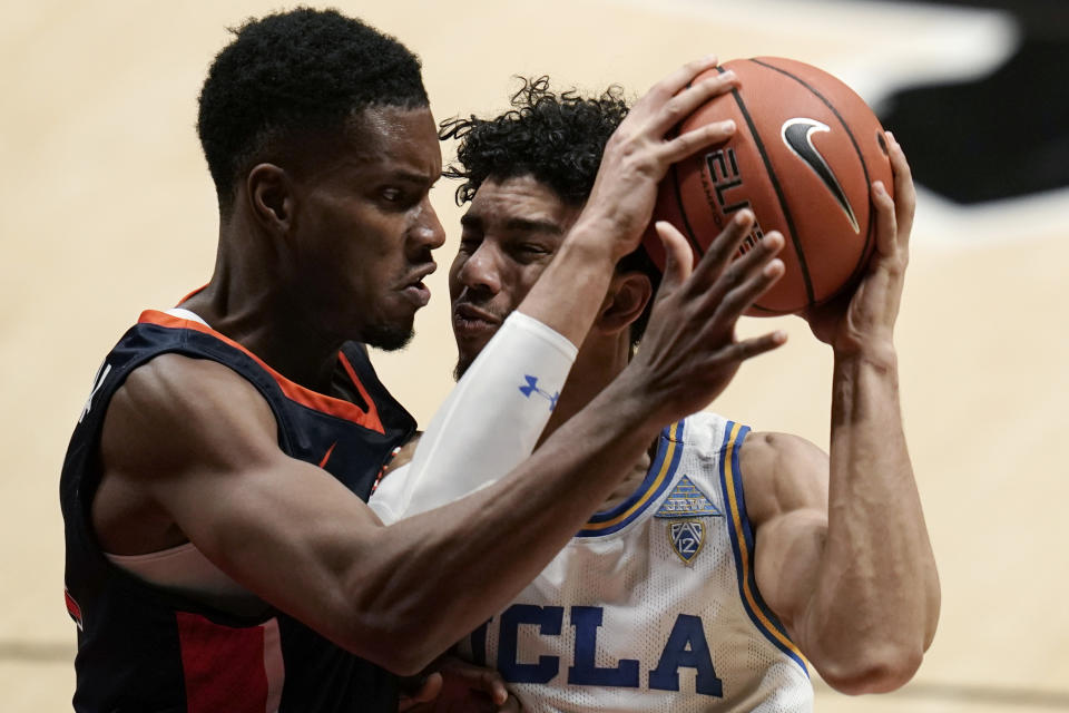 UCLA guard Jules Bernard, right, tries to get past Pepperdine center Victor Ohia Obioha during the second half of an NCAA college basketball game Friday, Nov. 27, 2020, in San Diego. (AP Photo/Gregory Bull)