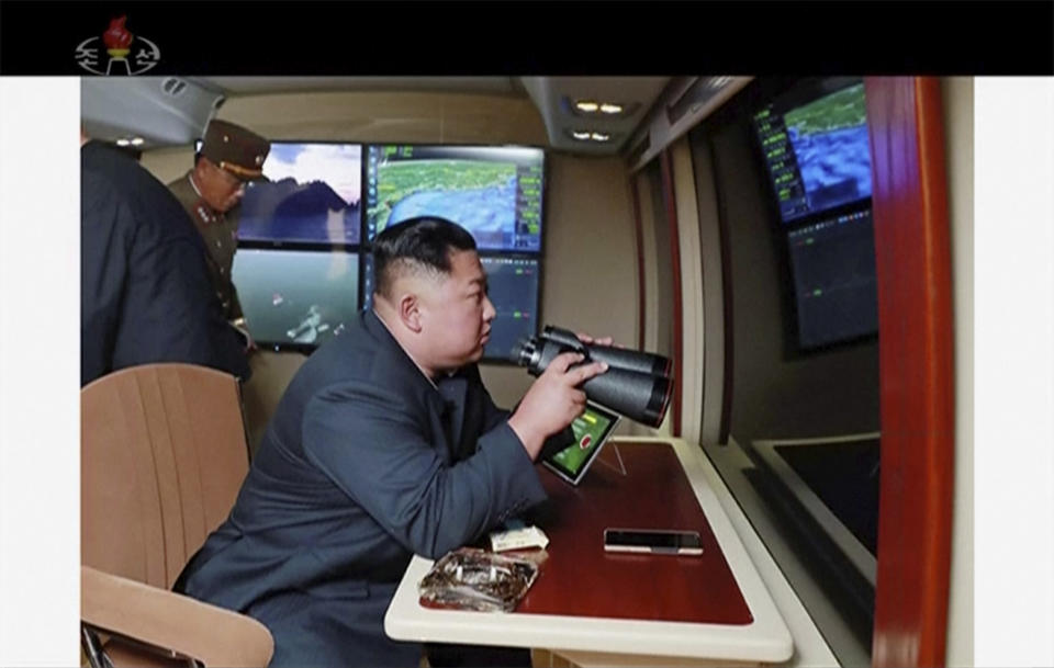 In this image made from video of a still image broadcasted by North Korea's KRT on Thursday, Aug. 1, 2019, North Korean leader Kim Jong Un, equipped with binoculars, supervises a rocket launch test. North Korea said Thursday, Aug. 1, leader Kim supervised the first test firing of a new multiple rocket launcher system that could potentially enhance its ability to strike targets in South Korea and U.S. military bases there.(KRT via AP Video)