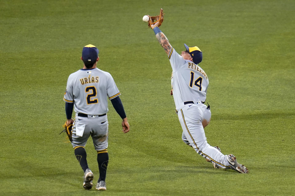 Milwaukee Brewers third baseman Jace Peterson (14) can't make the catch on a fly ball hit by Pittsburgh Pirates' Jack Suwinski during the sixth inning of a baseball game in Pittsburgh, Thursday, June 30, 2022. (AP Photo/Gene J. Puskar)