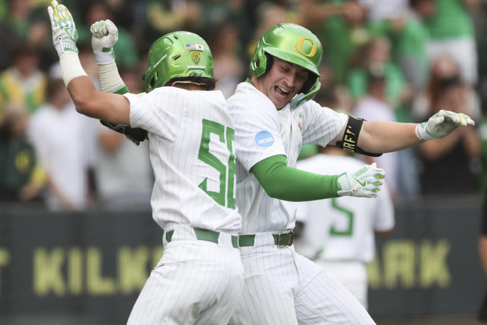 Oregon's Bennett Thompson, right, celebrates his three-run home run against Oral Roberts with Rikuu Nishida during the fourth inning of an NCAA college baseball tournament super regional game Friday, June 9, 2023, in Eugene, Ore. (AP Photo/Amanda Loman)